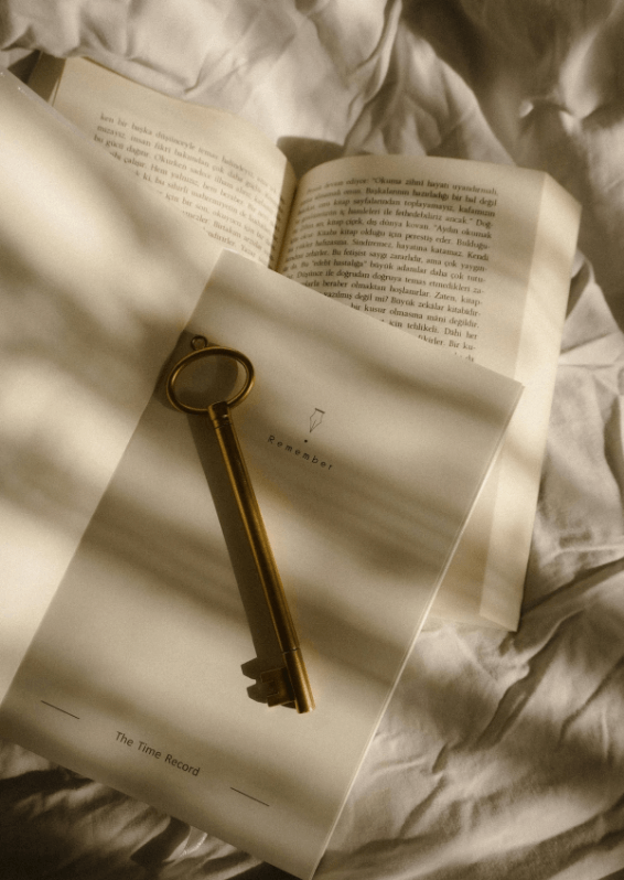 柔らかな光の中で、開かれた本の上に置かれたアンティークの鍵